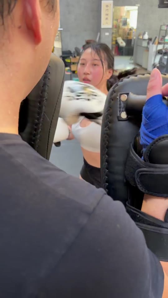HCF 學員戴拳套向教練手持的靶具練習出拳